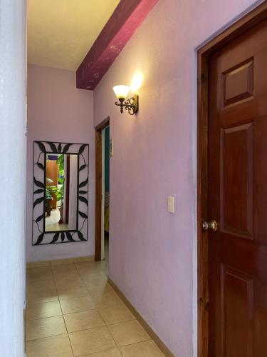 a hallway with a door and a mirror on the wall at Hospedaje Las Orquideas in Valle de Bravo