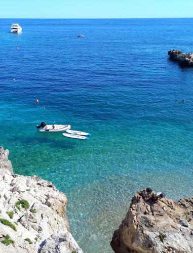 a boat in the water next to some rocks at Appartamento Luigi in Ventimiglia