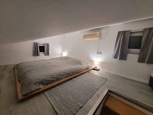 1 dormitorio con 1 cama grande en una habitación con 2 ventanas en Apartment Daniel, en Novalja