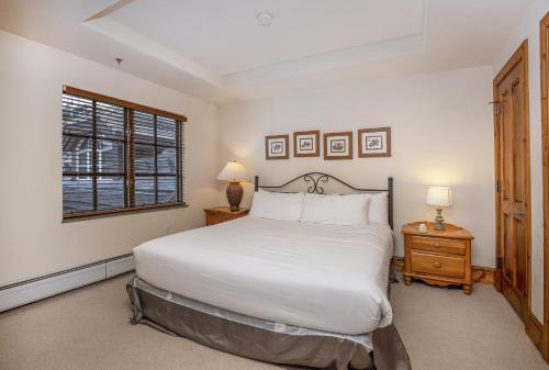 um quarto com uma grande cama branca e uma janela em Market Square 306 condo em Beaver Creek