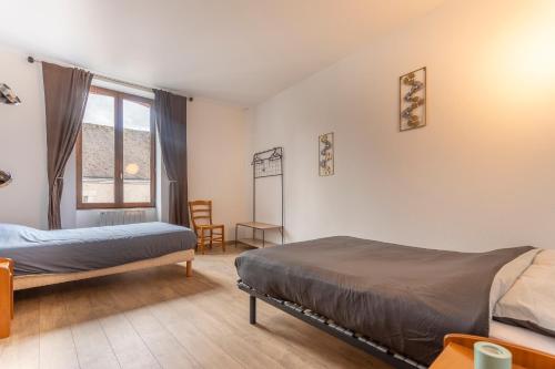 a bedroom with two beds and a window at Monesto Gite maison de ville cité médiévale in Mennetou-sur-Cher