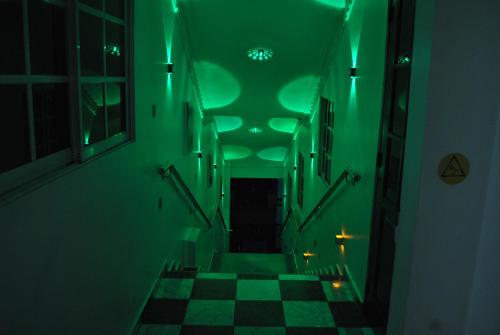 a green hallway with a checkered floor and stairs at Hotel Rey in Concepción de La Vega