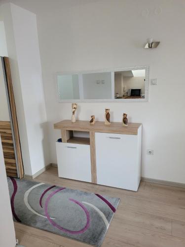 Zimmer mit einem Tisch, einem Spiegel und einem Teppich in der Unterkunft Sweet Home 2 in Niš
