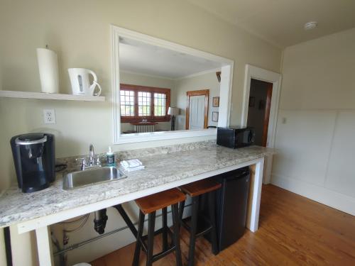 a kitchen counter with a sink and a mirror at Stonewater Manor B&B in Gananoque