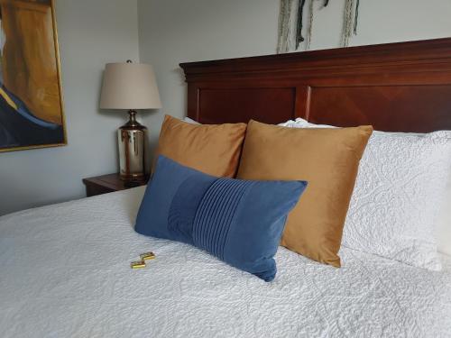 a blue pillow sitting on top of a bed with pillows at Stonewater Manor B&B in Gananoque