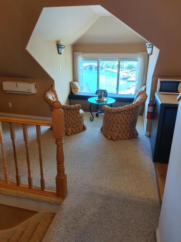 a room with a staircase with chairs and a table at Stonewater Manor B&B in Gananoque