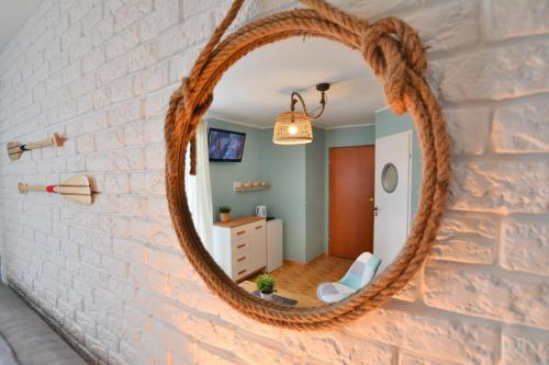 a round mirror on a brick wall in a room at Czarmorza Pokoje Gościnne in Mielno