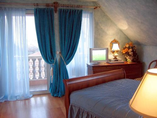 a bedroom with a bed and a window with blue curtains at VILLA MARJAN - 3 bdr, 3 bath, parking in Split