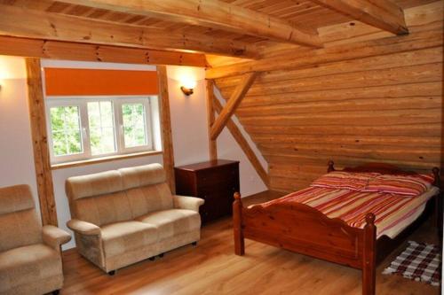 a bedroom with a bed and a chair in a cabin at Całoroczny dom w Powałczynie w spokojnej okolicy. in Powałczyn