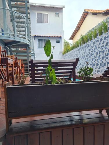 a bench with a plant in it on a patio at Pousada Caravela in Arraial do Cabo