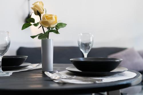 a table with two glasses and a vase with a yellow rose at 248 Boutique Studios, Sliema in Sliema