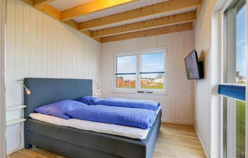 una camera con letto blu in una stanza con finestra di Amazing Home In Ostseeresort Olpenitz With Sauna a Olpenitz