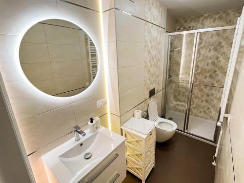 a bathroom with a sink and a mirror and a toilet at Villa Adele in Polanica-Zdrój