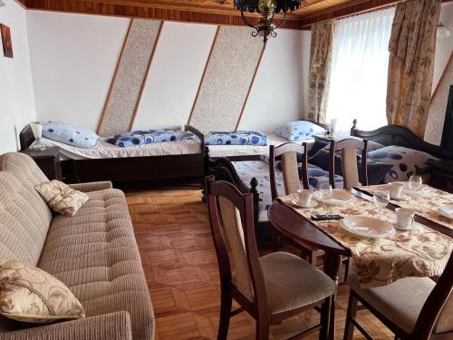 a room with a table and chairs and two beds at Barka in Ustka