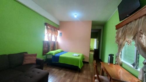 a bedroom with a bed and a couch in a room at Hotel del Carmen in Retalhuleu