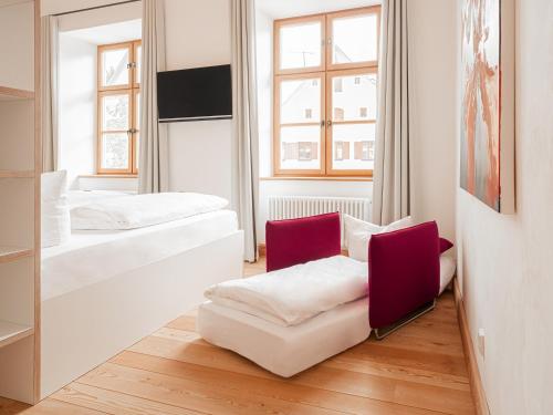 a living room with two beds and a chair at Post Berching in Berching