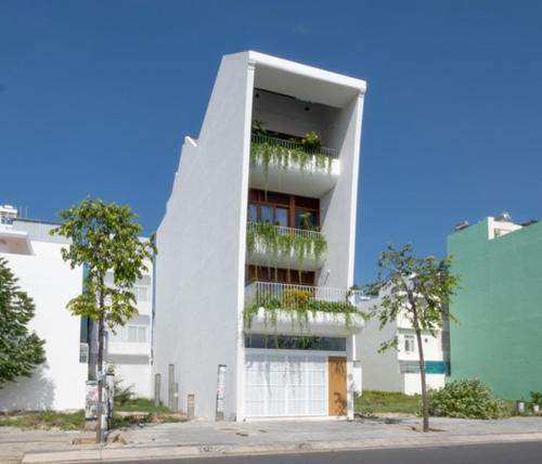 a white building with balconies and plants on it at Holi Terrace Villa in Nha Trang