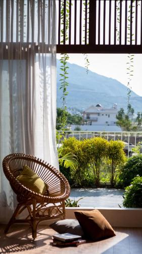a wicker chair sitting in a room with a window at Holi Terrace Villa in Nha Trang