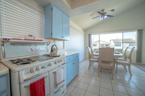 a kitchen with a stove and a dining room with a table at Ocean View / Pool Table / Surfboards / Beach Bikes in Oxnard
