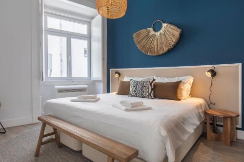 Ando Living - Abrantes Flats في لشبونة: غرفة نوم بسرير كبير بجدار ازرق