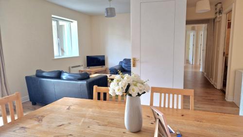 a vase of flowers on a table in a living room at Glen Abhainn Standard Budget Accommodation in Athlone