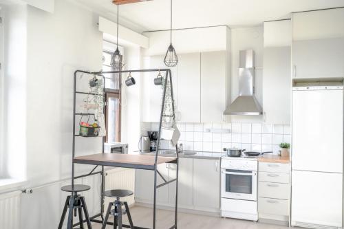 eine Küche mit weißen Schränken, einem Tisch und Stühlen in der Unterkunft The Sunset - Top Floor Studio apartment in Pietarsaari
