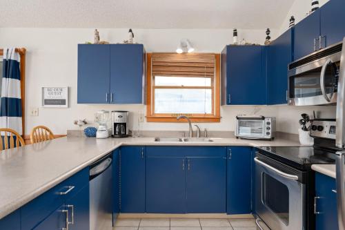 a kitchen with blue cabinets and a window at Siers Seashore in Waves