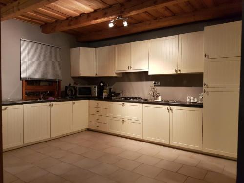 a kitchen with white cabinets and a white refrigerator at Misze Tanya in Alsóbene