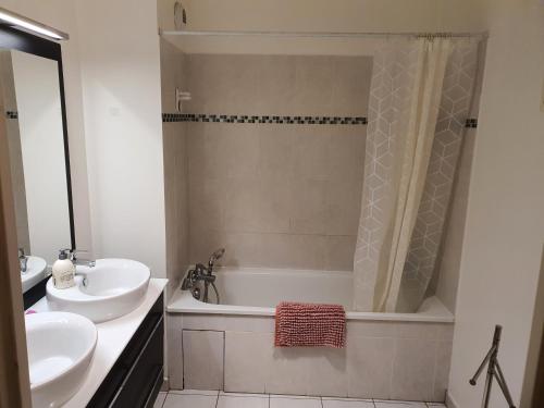 La salle de bains est pourvue d'une baignoire, d'un lavabo et d'une douche. dans l'établissement Bel appart climatisé, à Vigneux-sur-Seine