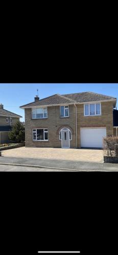 a large brick house with a white garage at Modern 4 bedroom house in Weymouth Sunny Corner in Weymouth