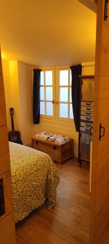 sypialnia z łóżkiem i oknem w obiekcie La Grange Climatisé w Bajonnie