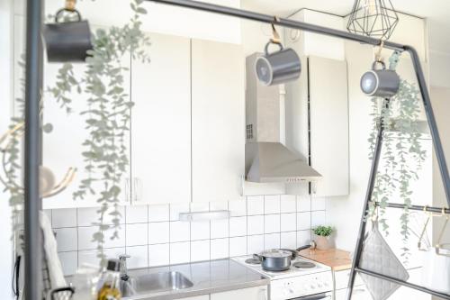 a kitchen with white cabinets and a sink at The Sunset - Top Floor Studio apartment in Pietarsaari