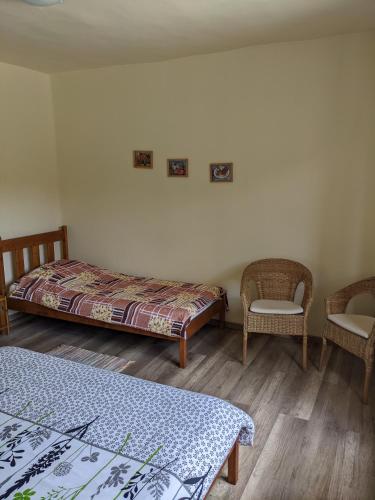 a bedroom with two beds and a chair at Tulipan Haz in Szilvásvárad