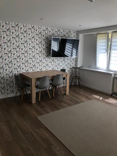 a dining room with a wooden table and chairs at Apartment Tarasy centrum in Siemiatycze