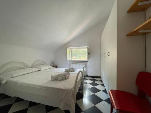 a bedroom with a white bed and a checkered floor at Ampia casa marinara con meravigliosa terrazza vista mare Da Mario e Rosanna in Portovenere