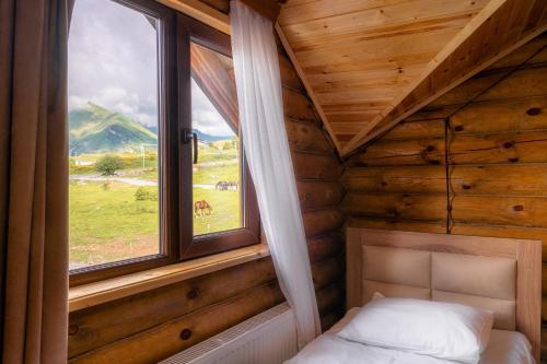 a bedroom with a window in a log cabin at Snow Time Eco Chalet in Gudauri