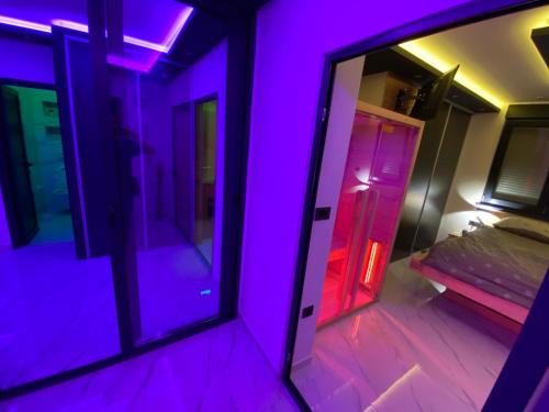 a purple room with a bed and a mirror at Wellness Apartment Kalypso in Osijek