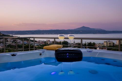 a bath tub with two wine glasses on a balcony at Villa Denise in Kalyves
