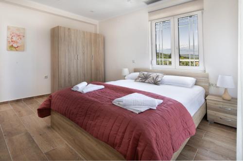 a bedroom with a large bed with two towels on it at Villa Denise in Kalyves