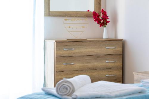 a bedroom with a dresser with a heart on the wall at Villa Denise in Kalyves