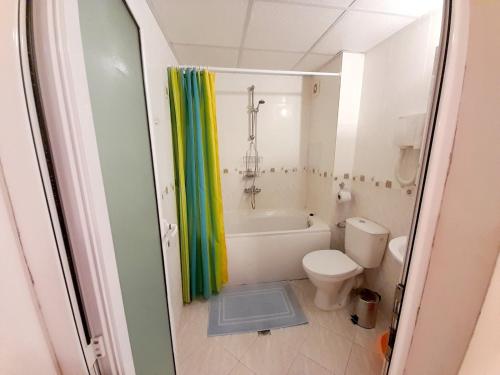 a bathroom with a tub and a toilet and a shower curtain at Sunny Beach Hills Apartment - Private in Sunny Beach