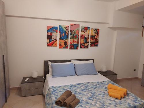 sypialnia z łóżkiem z dwoma obrazami na ścianie w obiekcie Villa Costanza Casa Vacanze w mieście Avola