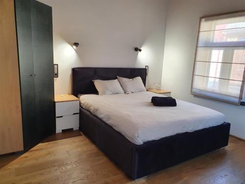 a bedroom with a large bed with a black headboard at KK Apartment in Ventspils