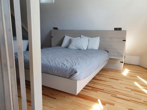 a bedroom with a bed with a wooden floor at KK Apartment in Ventspils