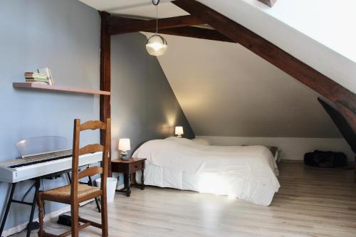 a bedroom with a bed and a desk and a piano at L'entre port & mer - Vue mer - Proxi gare plage & quai - Hyper-Centre - Parking gratuit in Dieppe