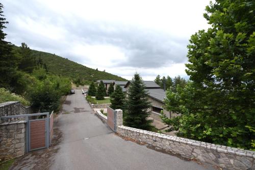 a road with a fence and a stone wall at Amfikleia Home by Relax in Greece in Amfiklia