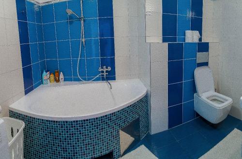 ein blau gefliestes Bad mit einer Badewanne und einem WC in der Unterkunft Panorama apartmán 44-C in Donovaly