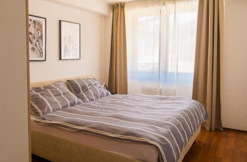 Schlafzimmer mit einem großen Bett und einem Fenster in der Unterkunft Panorama apartmán 44-C in Donovaly