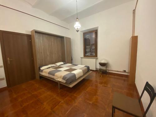 1 dormitorio con 1 cama y suelo de madera en ROBHOUSE, en Fabriano