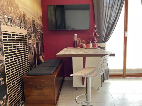 een bureau en een stoel in een kamer met een rode muur bij Studio Flat Policlinico G B Rossi Borgo Roma in Verona